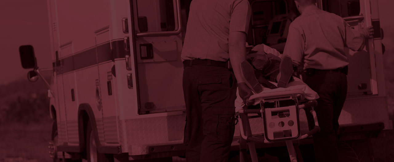 EMS providers or paramedics moving a crash victim into an ambulance